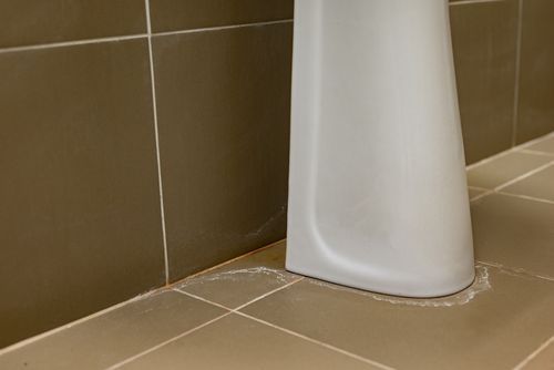 Image is of a leak under a sink concept of Palm Beach residential plumbing